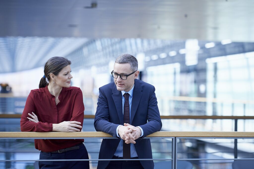 Businesswoman and man talking on office balcony